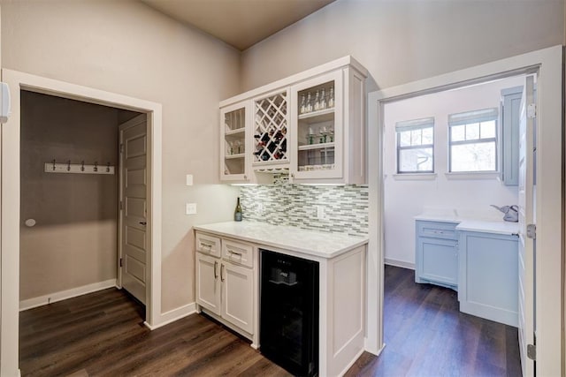 interior space with wine cooler, white cabinets, tasteful backsplash, dark wood finished floors, and glass insert cabinets