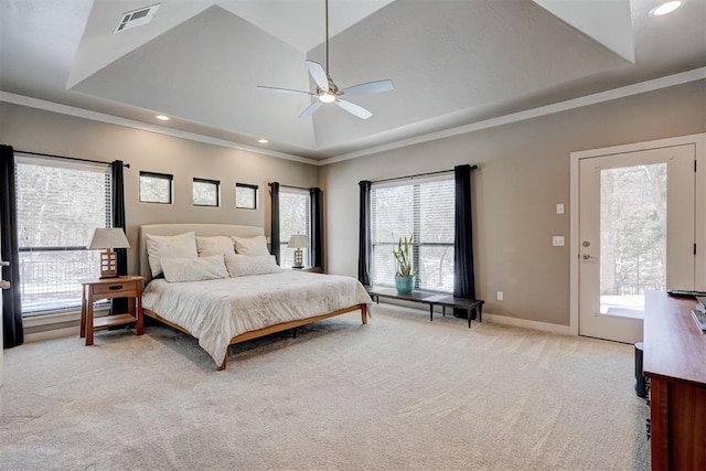 bedroom with a tray ceiling, visible vents, light carpet, and multiple windows