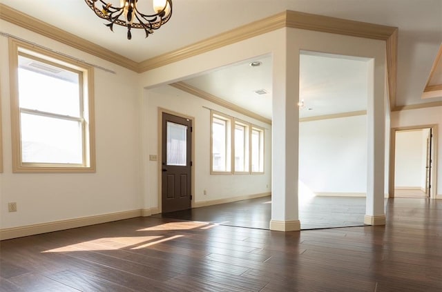 entryway with decorative columns, baseboards, dark wood-type flooring, crown molding, and a chandelier