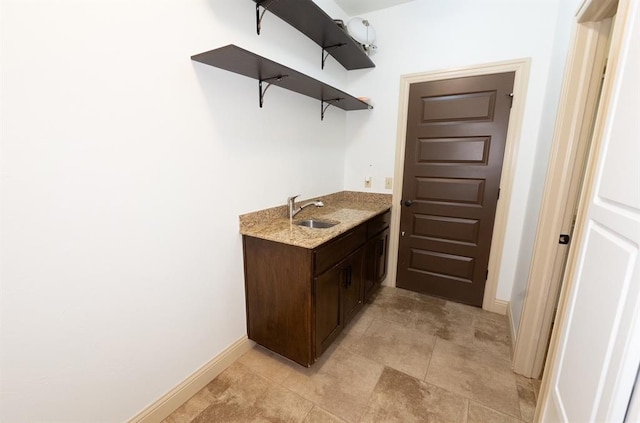 bar with baseboards and a sink