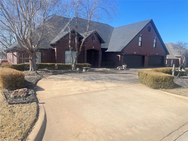 view of front facade featuring a garage, driveway, and brick siding