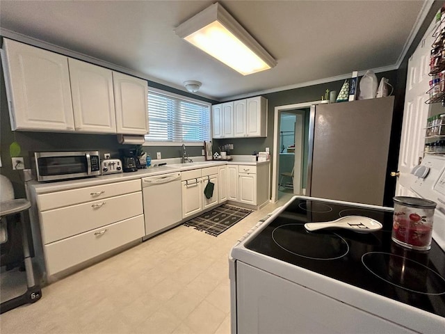 kitchen with appliances with stainless steel finishes, light countertops, light floors, white cabinetry, and a sink