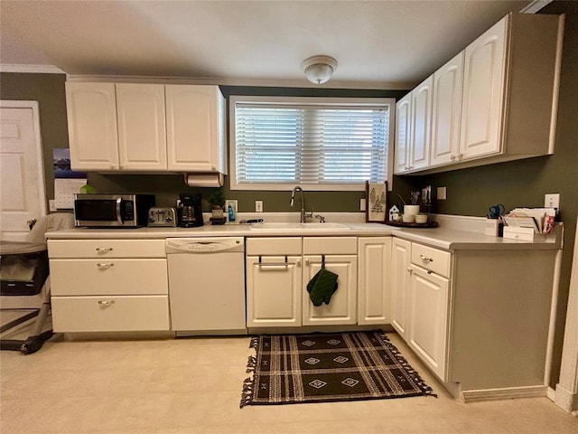 kitchen with white dishwasher, a sink, white cabinets, light countertops, and stainless steel microwave