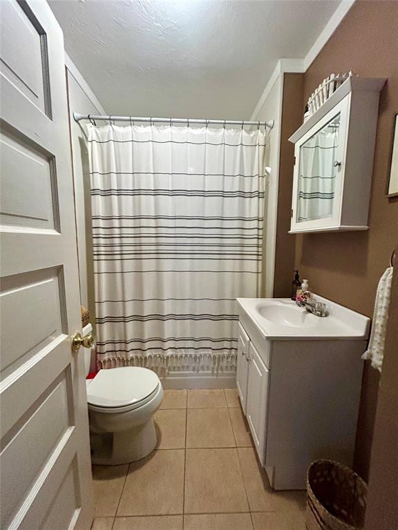 bathroom featuring shower / tub combo, toilet, tile patterned floors, crown molding, and vanity