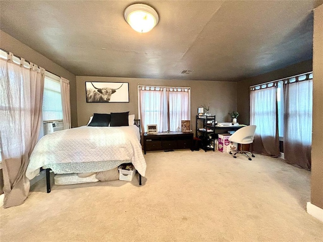 carpeted bedroom featuring multiple windows, cooling unit, and visible vents