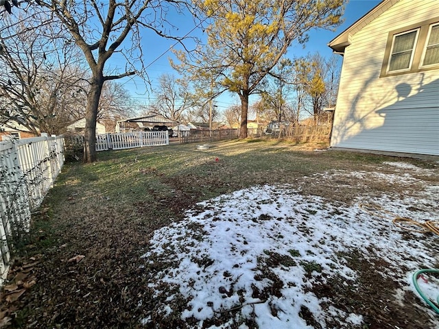 yard covered in snow with a fenced backyard