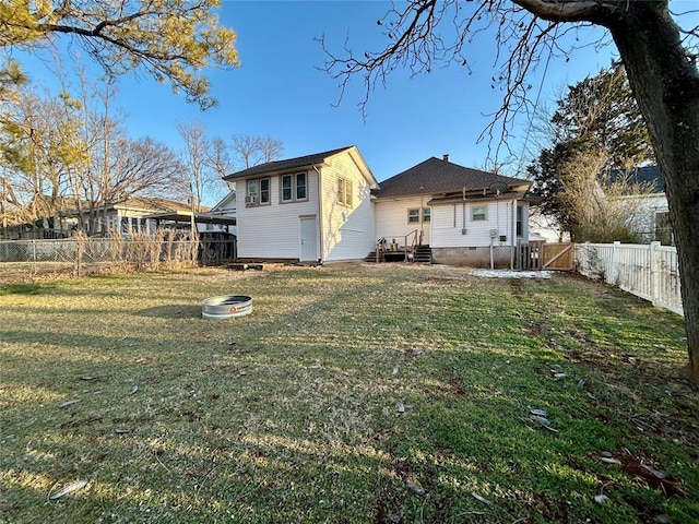 back of house featuring a lawn and a fenced backyard