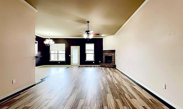 unfurnished living room with ornamental molding, a fireplace, light wood-style flooring, and baseboards