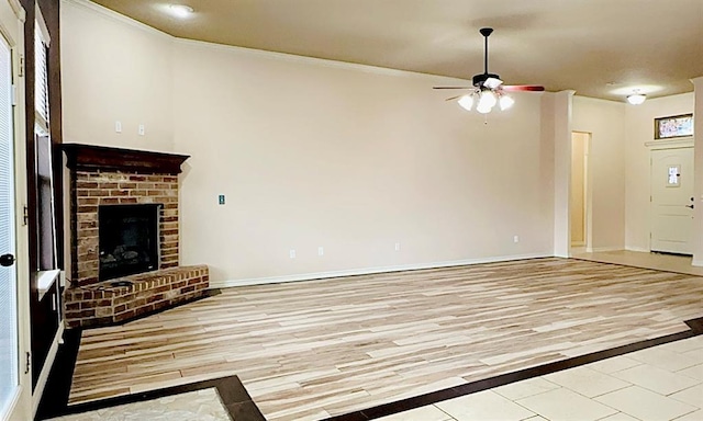 unfurnished living room with a ceiling fan, a brick fireplace, baseboards, and light wood finished floors