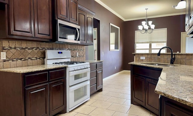 kitchen featuring decorative light fixtures, stainless steel microwave, a sink, light stone countertops, and double oven range