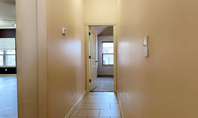 hall with light tile patterned floors and baseboards