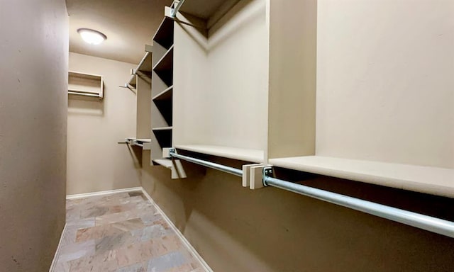 spacious closet featuring stone finish floor and a wall mounted AC