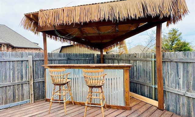 wooden terrace featuring fence and outdoor dry bar