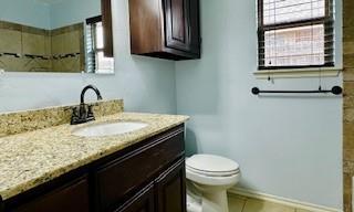 bathroom with tile patterned flooring, baseboards, vanity, and toilet