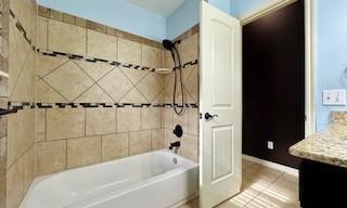 bathroom featuring tub / shower combination, vanity, and tile patterned floors