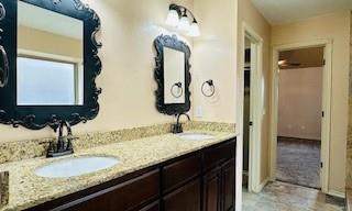 full bathroom with double vanity and a sink