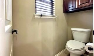 bathroom featuring toilet and baseboards