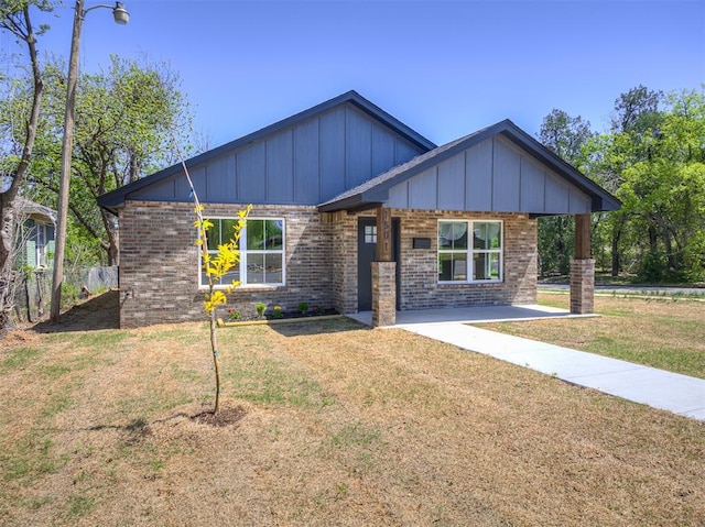 view of front of house featuring brick siding and a front lawn