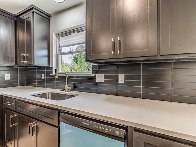 kitchen with a sink, light countertops, decorative backsplash, and dishwasher