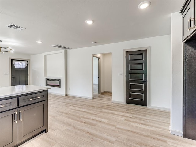 kitchen with light wood-style flooring, baseboards, and visible vents