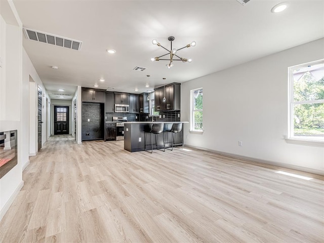kitchen with visible vents, recessed lighting, a breakfast bar, appliances with stainless steel finishes, and decorative backsplash