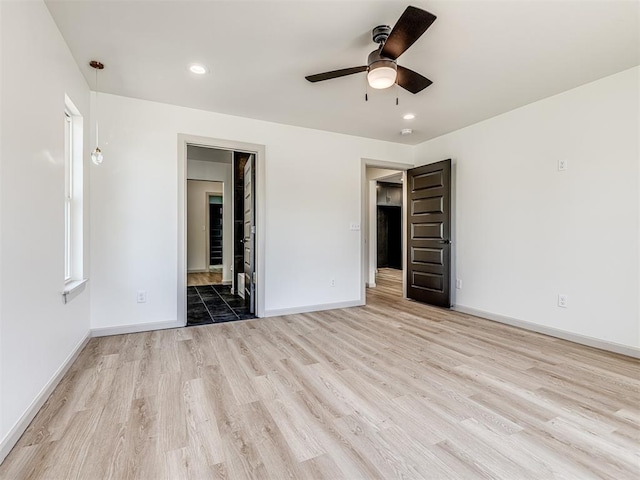 unfurnished bedroom with baseboards, a ceiling fan, recessed lighting, ensuite bath, and wood finished floors
