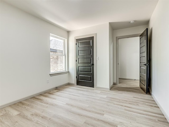 unfurnished bedroom with light wood finished floors and baseboards