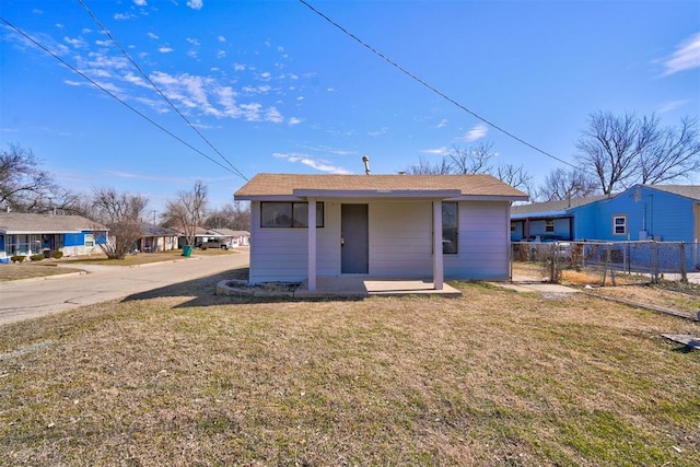 back of property featuring a lawn and fence