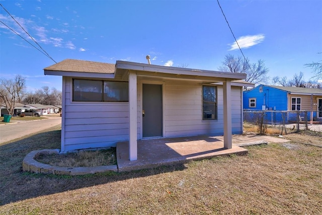 back of property featuring a yard, a patio area, and fence