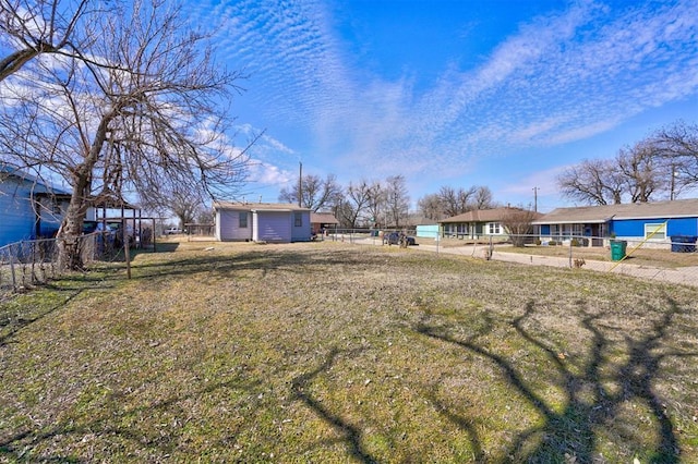 view of yard featuring an outdoor structure and fence