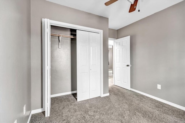 unfurnished bedroom featuring a closet, dark carpet, a ceiling fan, and baseboards