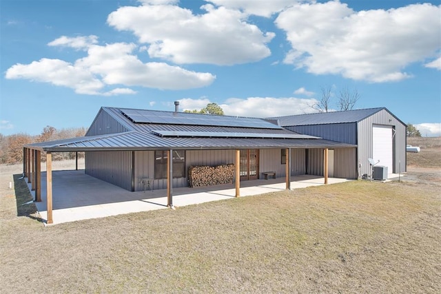 rear view of property featuring a carport, metal roof, and a patio