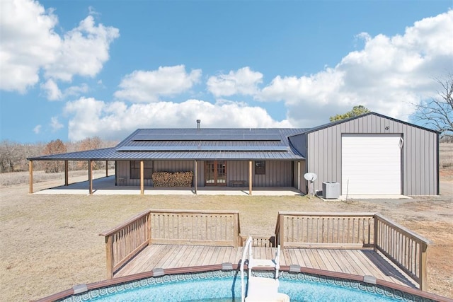 pool featuring a deck, a yard, an outdoor structure, and cooling unit