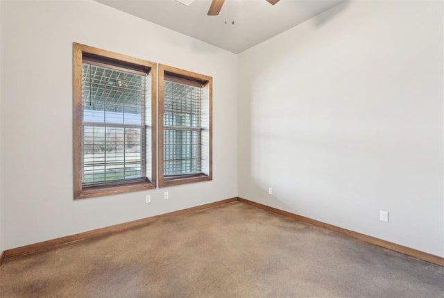 carpeted spare room with ceiling fan and baseboards