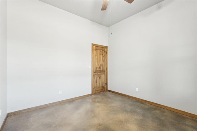 spare room with a ceiling fan and baseboards