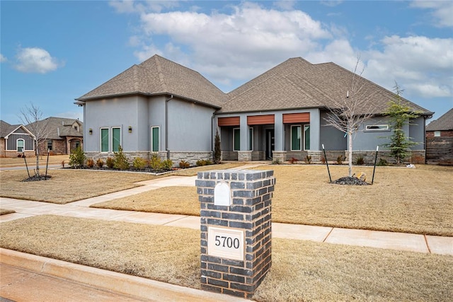 view of front of house with stone siding, roof with shingles, and stucco siding