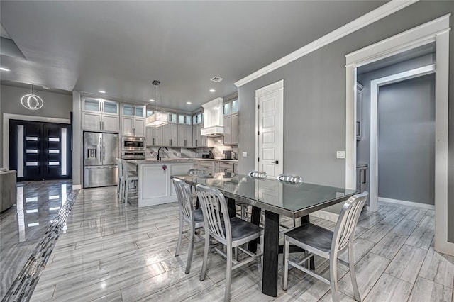 dining room with visible vents, crown molding, baseboards, wood tiled floor, and recessed lighting