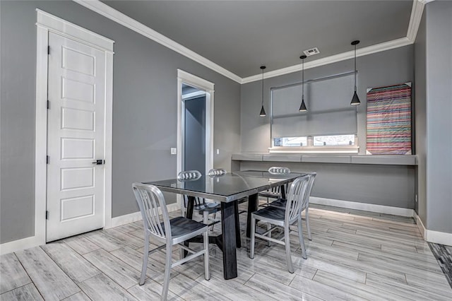 dining room with wood tiled floor, baseboards, visible vents, and ornamental molding