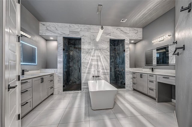 full bath featuring a shower stall, two vanities, and tile walls