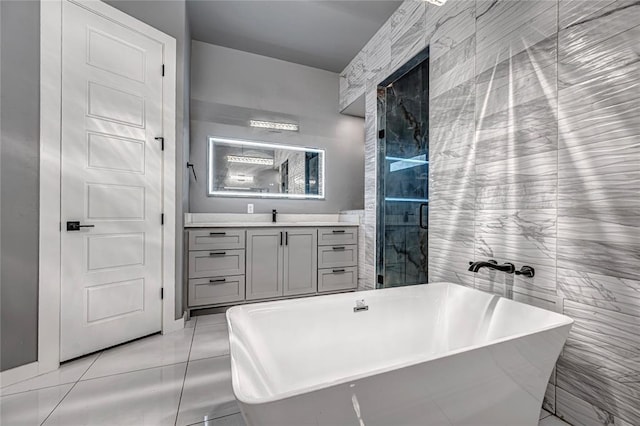 bathroom featuring tile patterned floors, a shower with shower door, vanity, and a freestanding tub