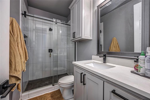 bathroom featuring tile patterned floors, a shower stall, toilet, and vanity