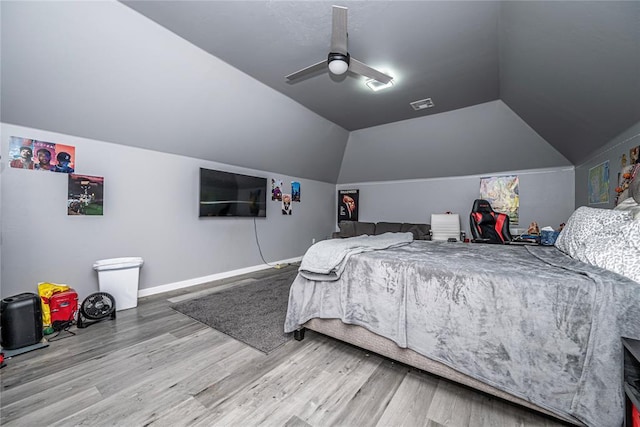 bedroom with visible vents, ceiling fan, baseboards, lofted ceiling, and wood finished floors