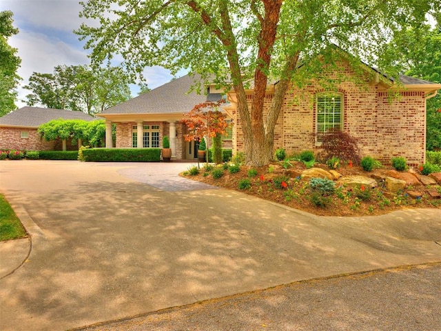 view of front of house featuring brick siding and concrete driveway