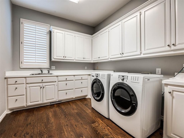 laundry area with dark wood-style floors, cabinet space, independent washer and dryer, and a sink