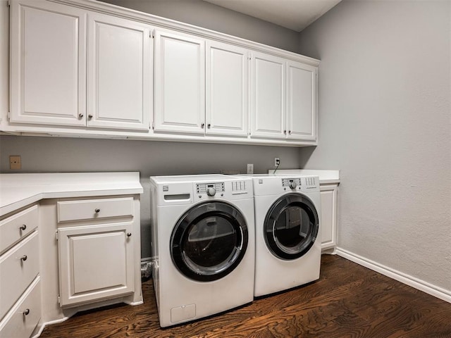 laundry room with baseboards, cabinet space, dark wood finished floors, and washing machine and clothes dryer