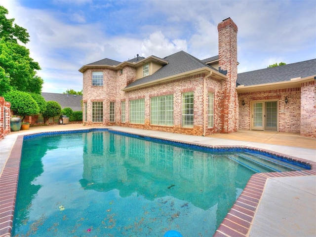 view of swimming pool featuring a patio, a fenced in pool, and french doors