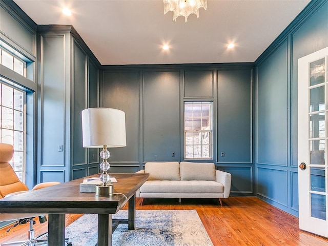 living room with recessed lighting, light wood finished floors, ornamental molding, and a decorative wall