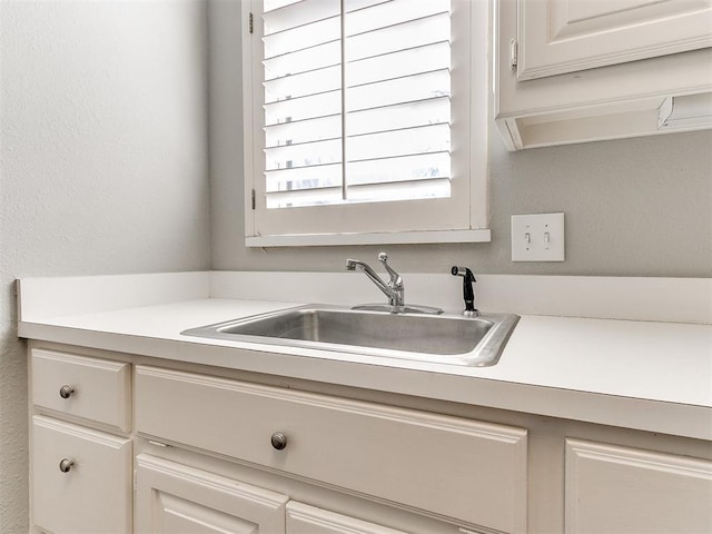 kitchen featuring a sink and light countertops