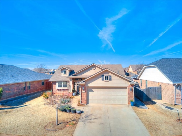 view of front of house with an attached garage, brick siding, fence, driveway, and a residential view