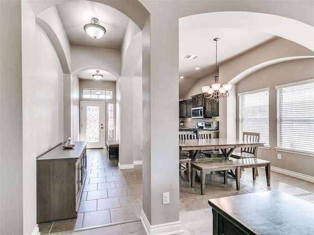 entrance foyer with a healthy amount of sunlight, baseboards, visible vents, and a notable chandelier